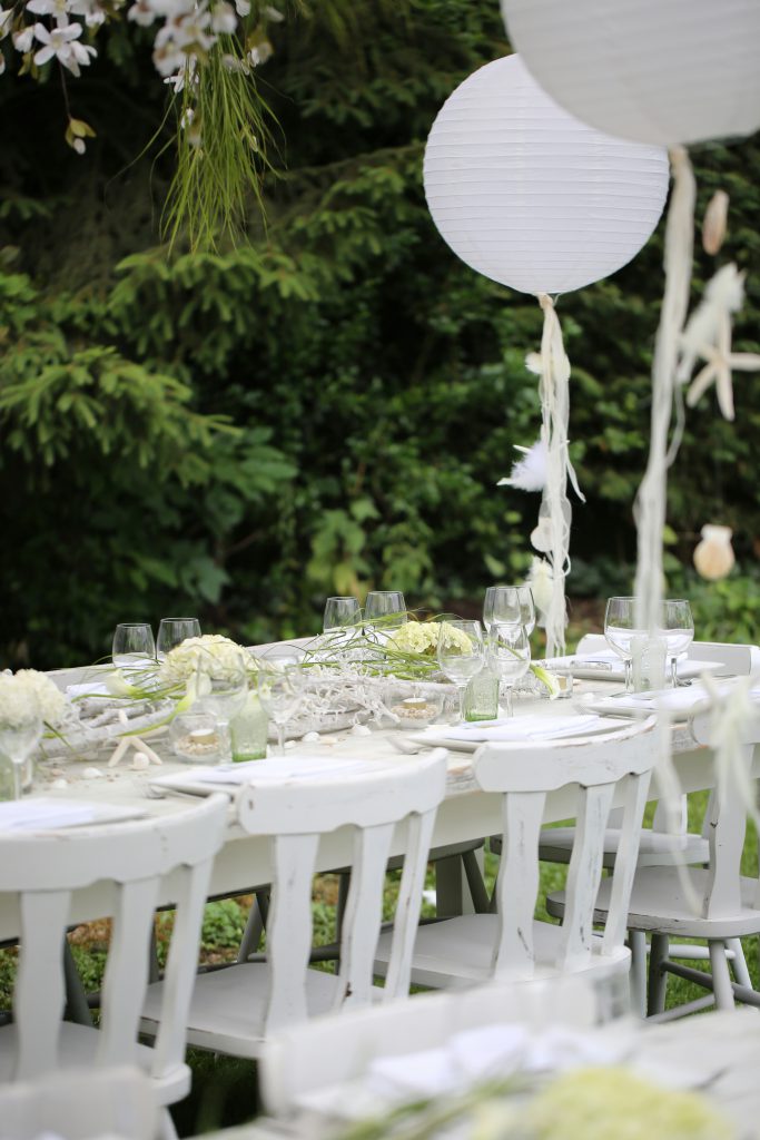 Tables dressées de blanc sous les arbres